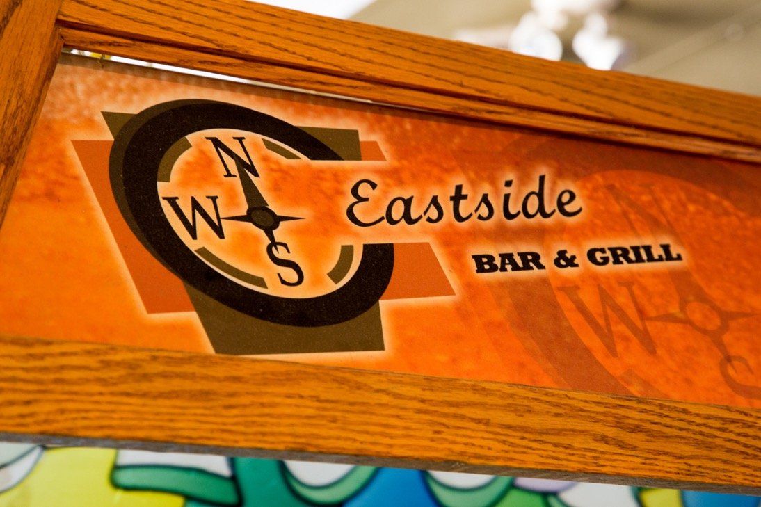 Carved wooden Eastside Bar & Grill compass sign